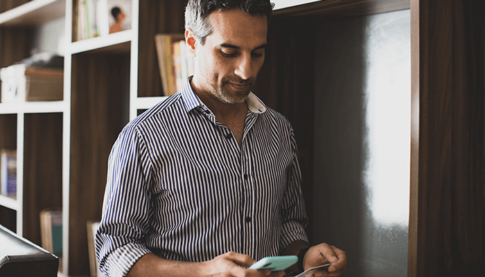 Emprendedor con celular en mano y tarjeta para relizar pago en línea