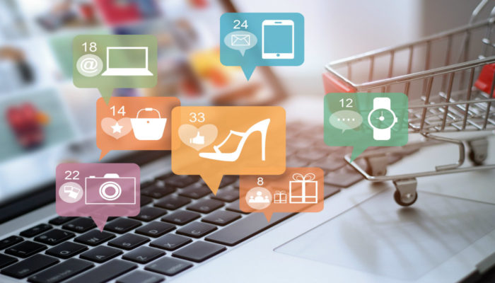 Como usar as mídias sociais a favor do seu e-commerce? Teclado de computador com miniatura de carrinho de compras representa as mídias sociais para ecommerce