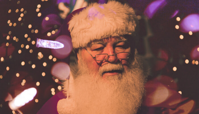7 conselhos do Papai Noel para a sua loja virtual Rosto do Papai Noel com seu típico chapéu vermelho, barba branca comprida e óculos