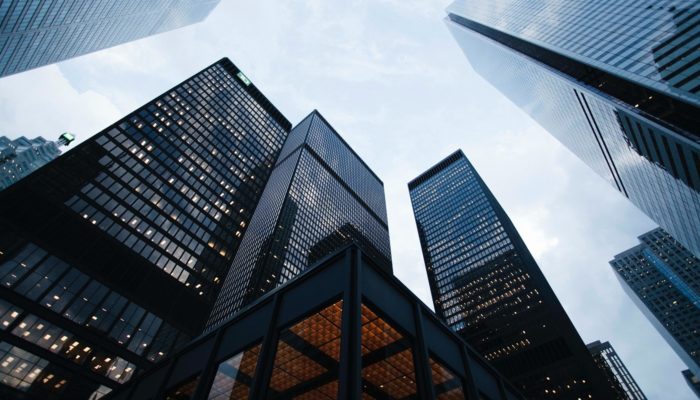 Qual é o melhor banco para abrir conta MEI? Vista de baixo de prédios comerciais, representando banco para abrir uma conta mei