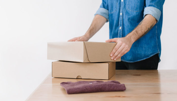 Cómo vender en Mercado Libre por primera vez Hombre envolviendo un producto