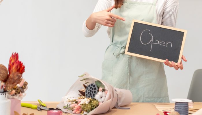 5 ventajas del comercio electrónico mujer florista con pizarrón de negocio abierto