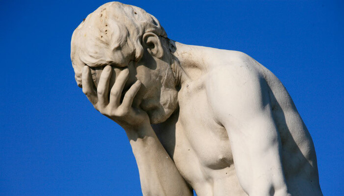 7 erros do e-commerce que fazem perder vendas na sua loja online Imagem de estátua com mão na testa e expressão de lamento, representando dicas de como não perder vendas no e-commerce