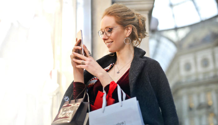 mulher usando o celular para fazer uma compra, representando os micro-momentos