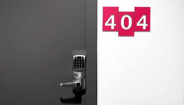 Foto de porta fechada com fechadura eletrônica e placa com o número 404 a lado da porta, representando o site fora do ar