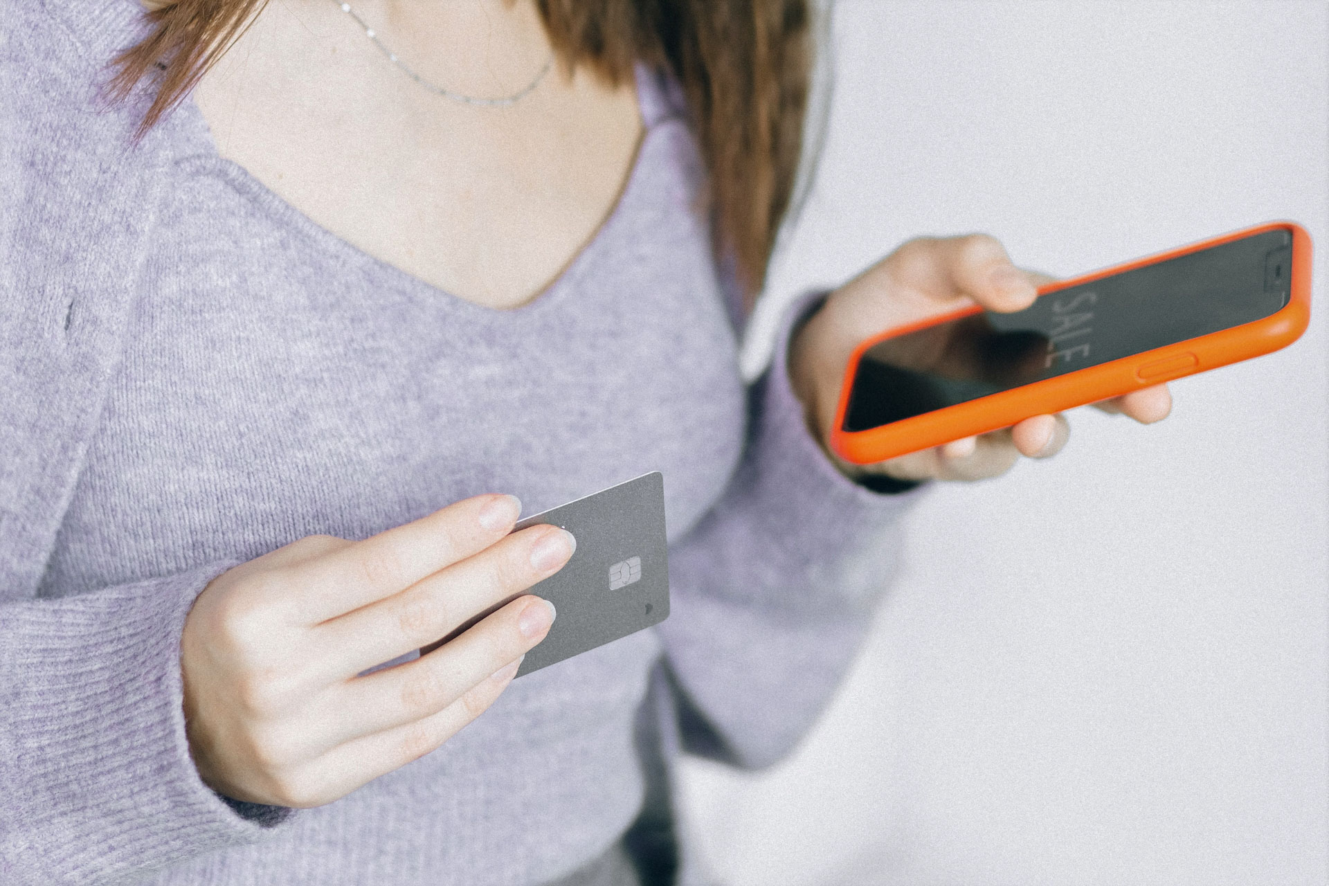 Medios de pago electrónico. Mujer con tarjeta de crédito y dispositivo móvil en mano