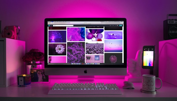 Os 10 melhores layouts da Nuvemshop em 2020 Imagem mostrando um computador exibindo imagens aleatórias em tons de roxo.