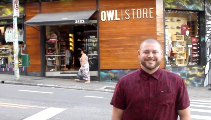 Fundador da Owl Store em frente à loja