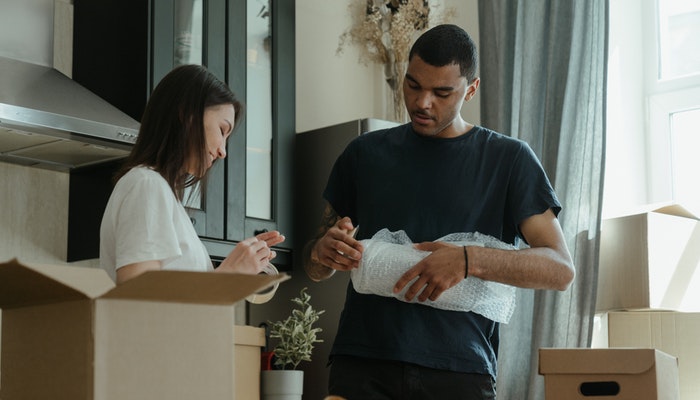 Como fazer o envio de produtos em sua loja Nuvemshop? Imagem mostrando pessoas separando pacotes para envio.