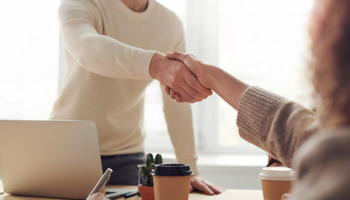 Cómo conseguir inversionistas: nuestros consejos y aprendizajes un hombre y una mujer dándose un apretón de manos en una oficina