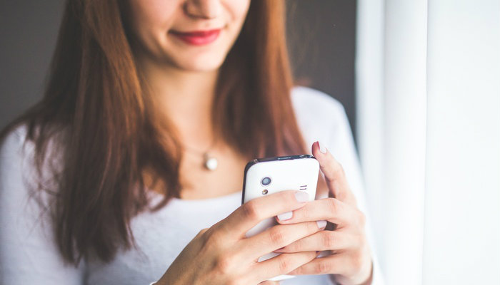 Como criar uma página adaptável a celulares Mulher usando celular para navegar na internet