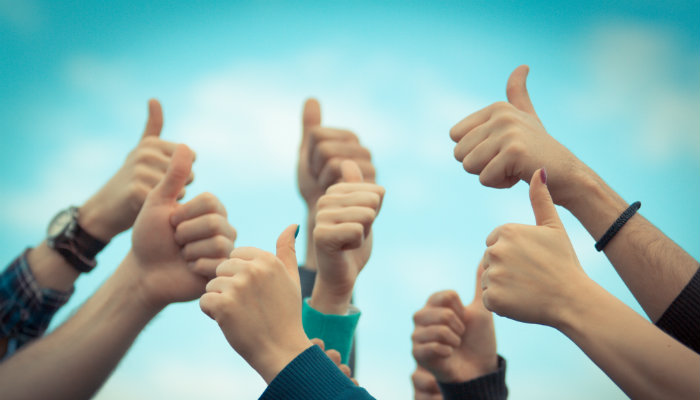 O que é qualidade total e melhoria contínua em um e-commerce? Mãos fazendo sinal de positivo, representando a qualidade no ecommerce