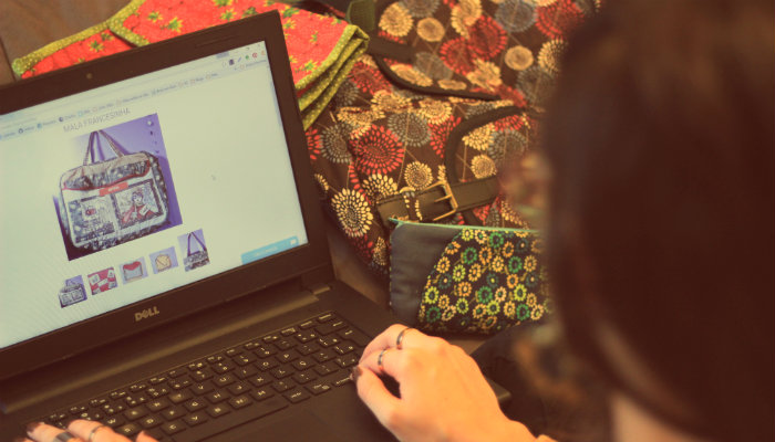 Como escolher o produto certo para vender na internet Mulher olha bolsa em página de produto online