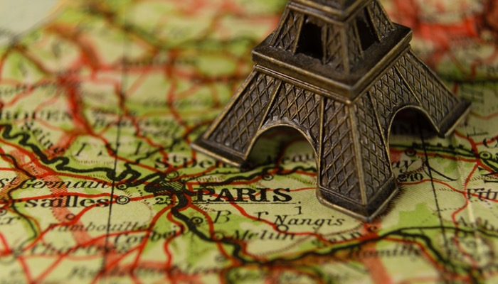 Ela ganha dinheiro viajando o mundo: conheça a história de Priscila Kamoi Miniatura de Torre Eiffel sobre mapa representa como ganhar dinheiro viajando