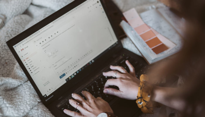 Pasos y herramientas para crear un correo institucional gratis Mujer escribiendo un e-mail desde una laptop