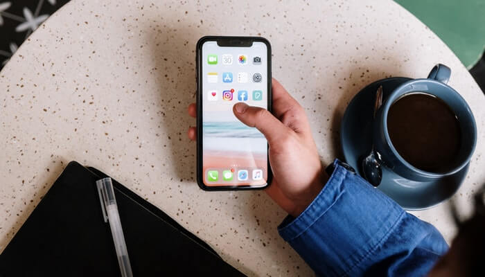 Instagram Stories: como as marcas podem aproveitar essa nova funcionalidade Mão de mulher segura smartphone com ícone do Instagram em evidência