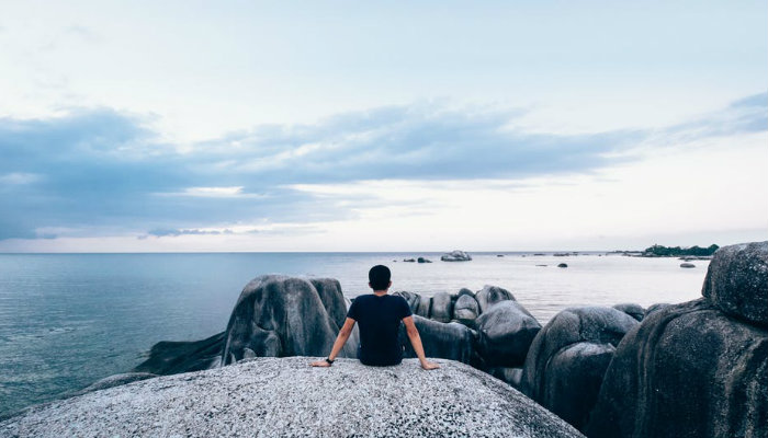 5 lições aprendidas no livro “Essencialismo”, de Greg McKeown Homem observa o horizonte na praia, representando as lições do livro Essencialismo
