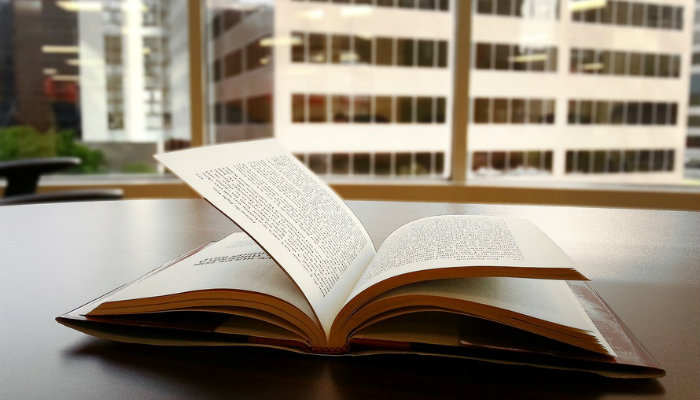 20 livros que irão te ensinar e inspirar a construir o sucesso do seu negócio Livro aberto sobre a mesa representa os livros de empreendedorismo