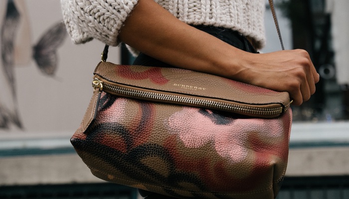 Midult: conheça o segmento de consumidoras que é tendência para seu e-commerce Mulher segura bolsa, representando o segmento midult