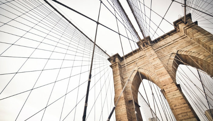 Mudanças na estratégia de link building que você precisa fazer hoje para ganhar autoridade Ponte ligada por fios representando o link building