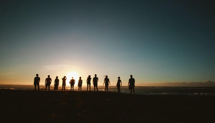 Definindo o alcance do seu negócio: qual é o seu público-alvo? Pessoas em praia contra o sol representando público-alvo