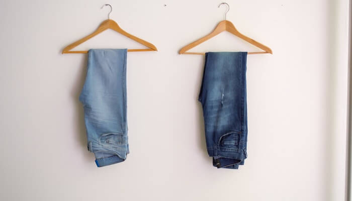 Scarcity: a abordagem de urgência que pode fazer maravilhas pelo seu negócio Dois cabides com uma calça jeans cada pendurada representam a técnica de scarcity