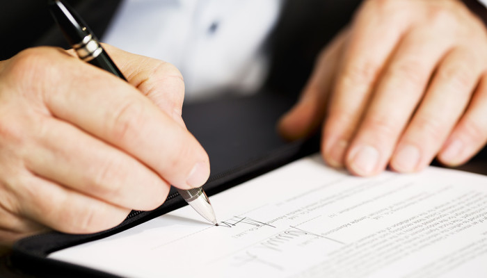 Serviços digitais: tudo que você precisa saber para um contrato confiável Mãos assinando contrato de serviços digitais