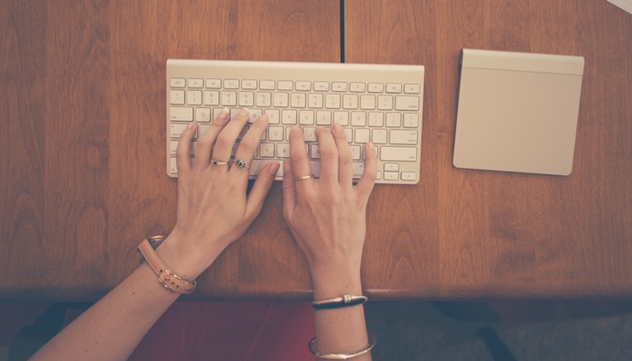 Speaklyn: saiba como atrelar o Facebook Messenger à sua loja virtual Mulher digita em teclado de computador, representando o Speaklyn