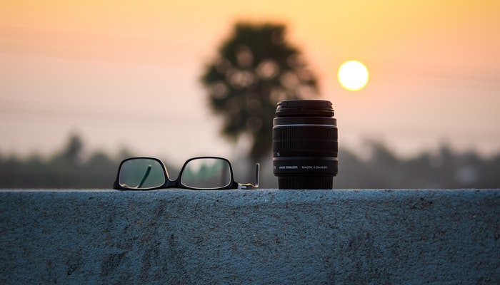 6 dicas para vender no Instagram Óculos e lente sobre mureta ao pôr do sol representam vender no Instagram