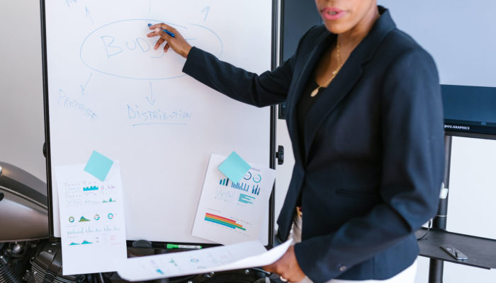 Plan de negocios: ¿qué es y qué información contiene? Mujer presentando un plan de negocios