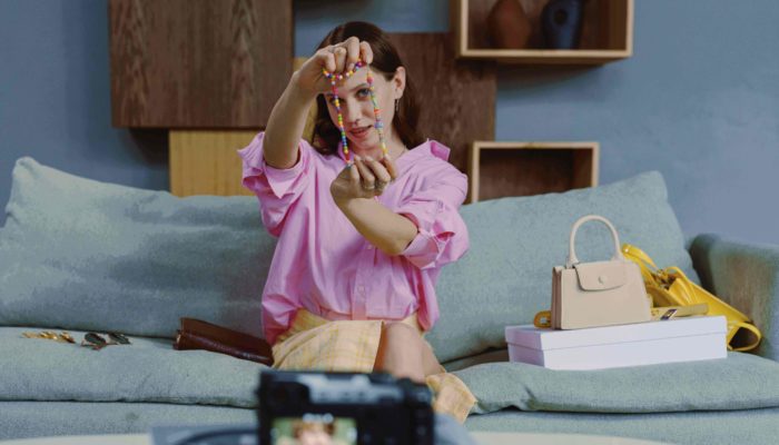 ¿Qué es y cómo ser influencer? 6 claves para lograrlo mujer influencer mostrando un collar a la cámara