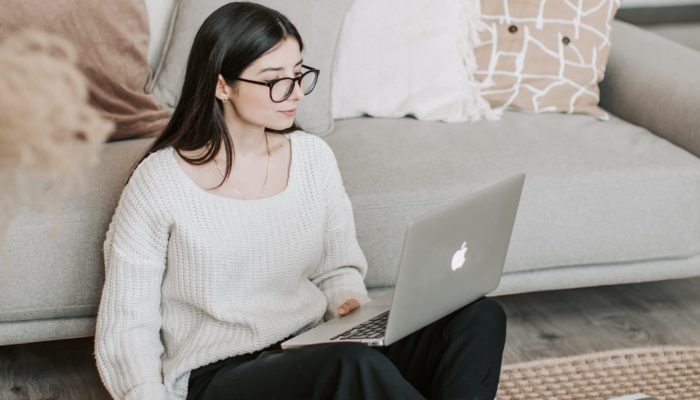 Mujer joven emprendedora frente a laptop para crear las redes sociales de su negocio