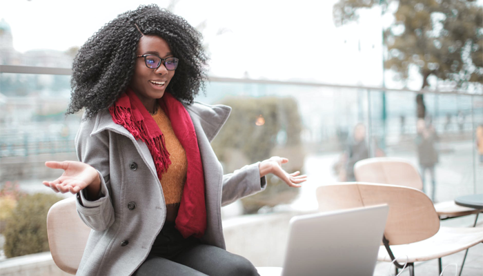 Conheça o Blogger e crie seu blog gratuito em 7 passos Mulher negra empolgada ao criar seu blog no Blogger em frente a um notebook