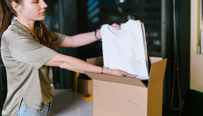 Imagem mostrando uma mulher preparando uma entrega, representando se dropshipping vale a pena.