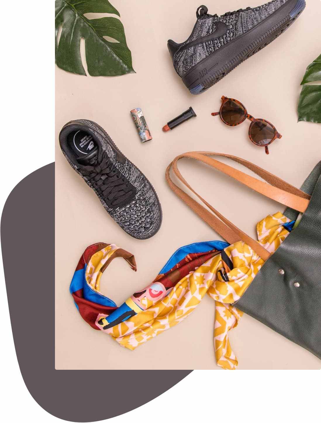Bolsa, mascada, lentes de sol, zapato deportivo y otros productos sobre una superficie