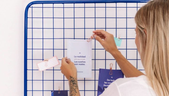 Manos de mujer colgando un cartel con las frases de emprendedores mÃ¡s motivadoras