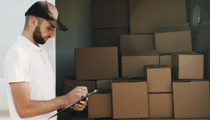 Homem fazendo entregas de caixas representando frete CIF