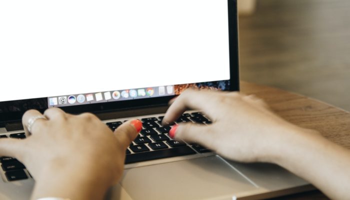 Assuntos para e-mail marketing: confira dicas e boas práticas Imagem mostrando uma pessoa digitando uma mensagem em um laptop, representando assuntos para e-mail marketing.