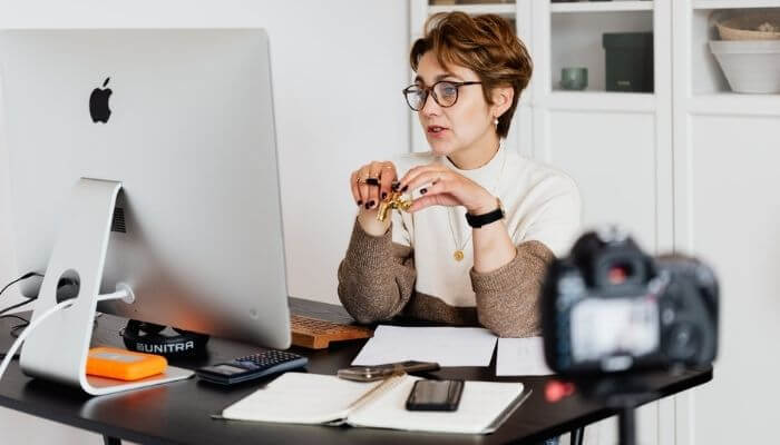 mulher em frente a um computador, participando de um curso de marketing digital