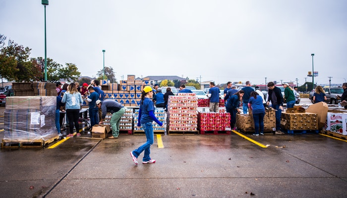 Imagem mostrando pessoas organizando caixas, representando a logística empresarial.