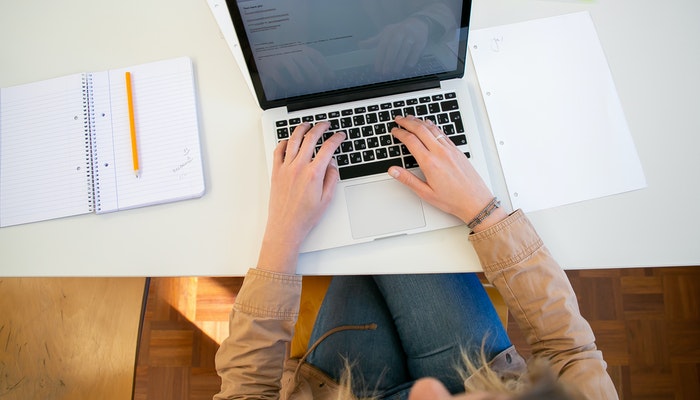 Imagem mostrando uma mulher digitando em um laptop, representando a criação de uma meta description.