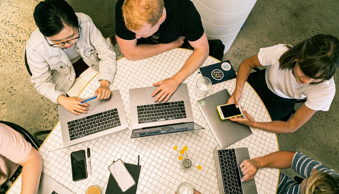 Qual a diferença entre MQLs e SQLs? Imagem mostrando uma equipe de profissionais trabalhando, representando as estratégias de MQ e SQL.