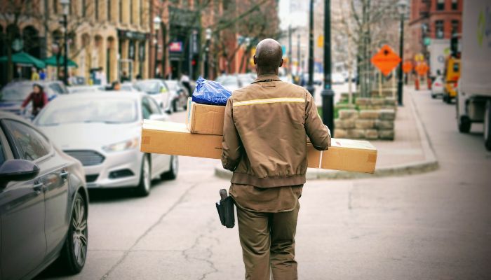 Homem carrega encomendas, representando o prazo de entrega no dropshipping