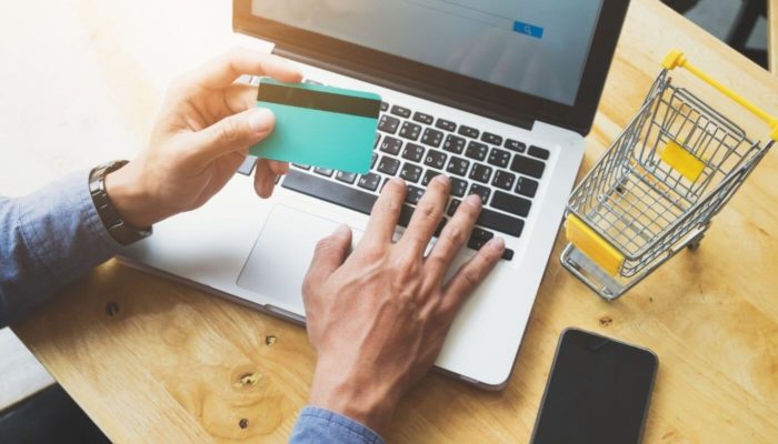 O que é e como funciona a venda digitada? homem digita dados de cartão de crédito para finalizar uma compra, exemplificando o que é venda digitada