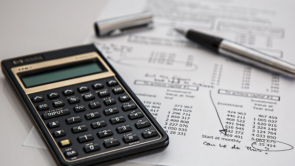 Presupuesto financiero una calculadora y pluma sobre una mesa blanca