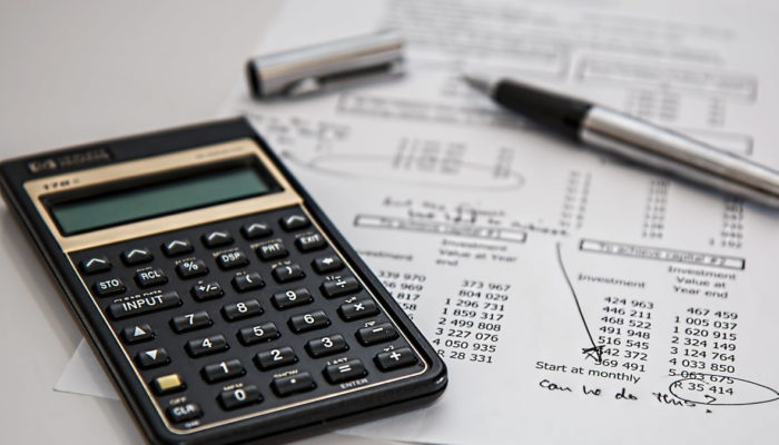 Presupuesto financiero una calculadora y pluma sobre una mesa blanca
