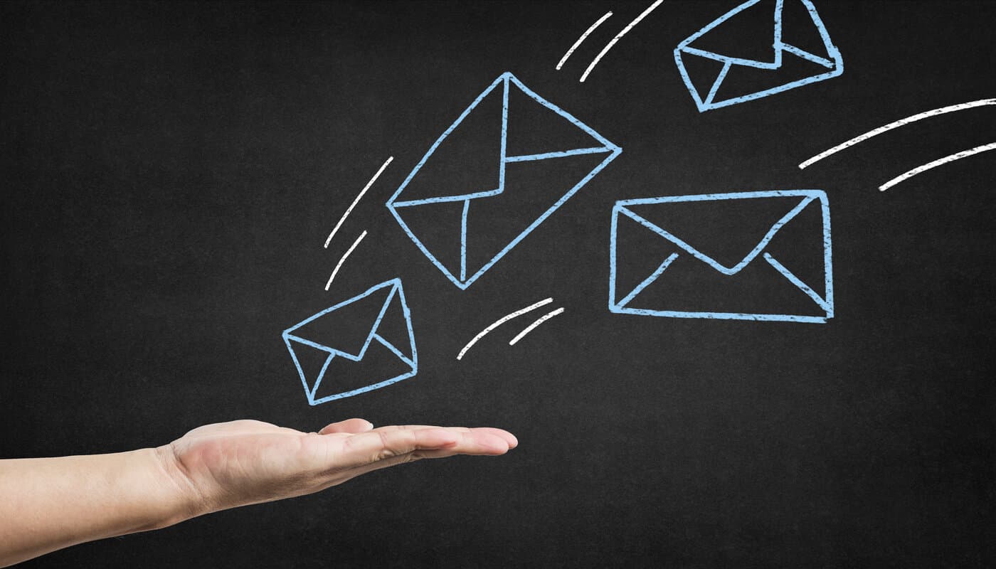 Imagem mostrando uma mão e vários envelopes desenhados representando os tipos de e-mail marketing