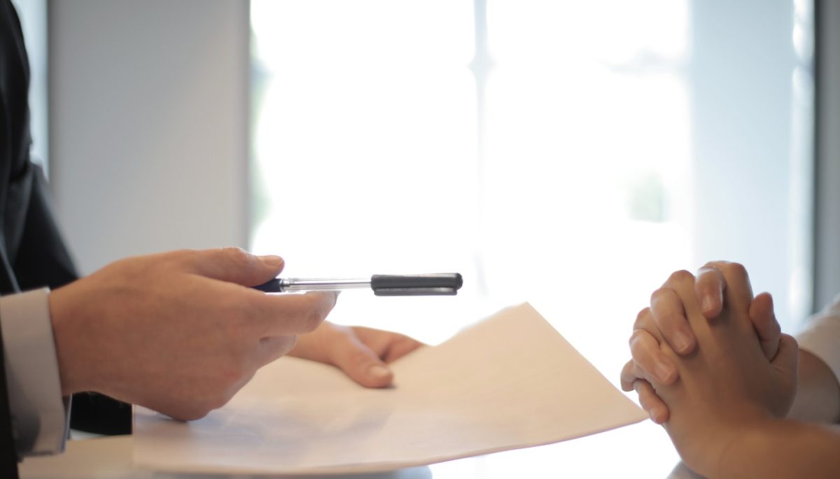 Imagem mostrando a assinatura de um contrato, representando o compliance dentro de uma empresa.