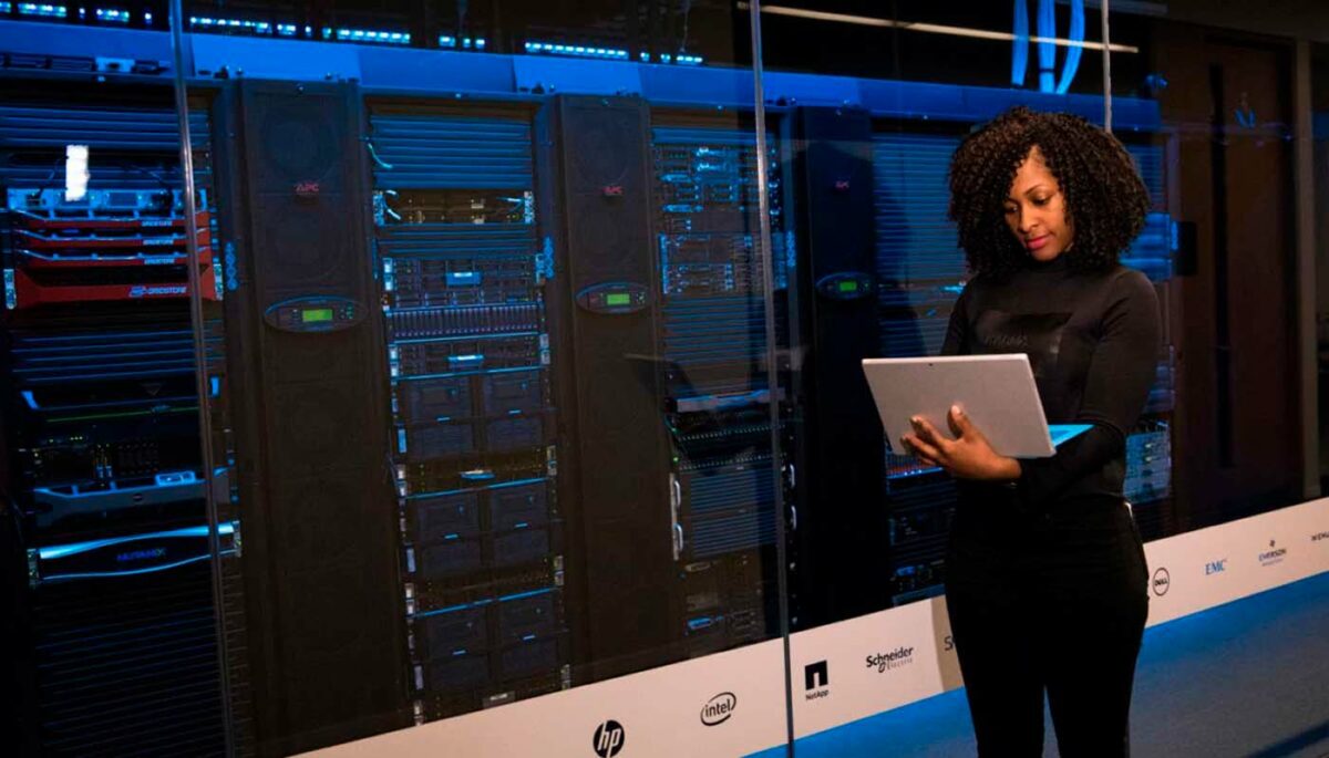 Mulher com notebook em data center simboliza o Big Data