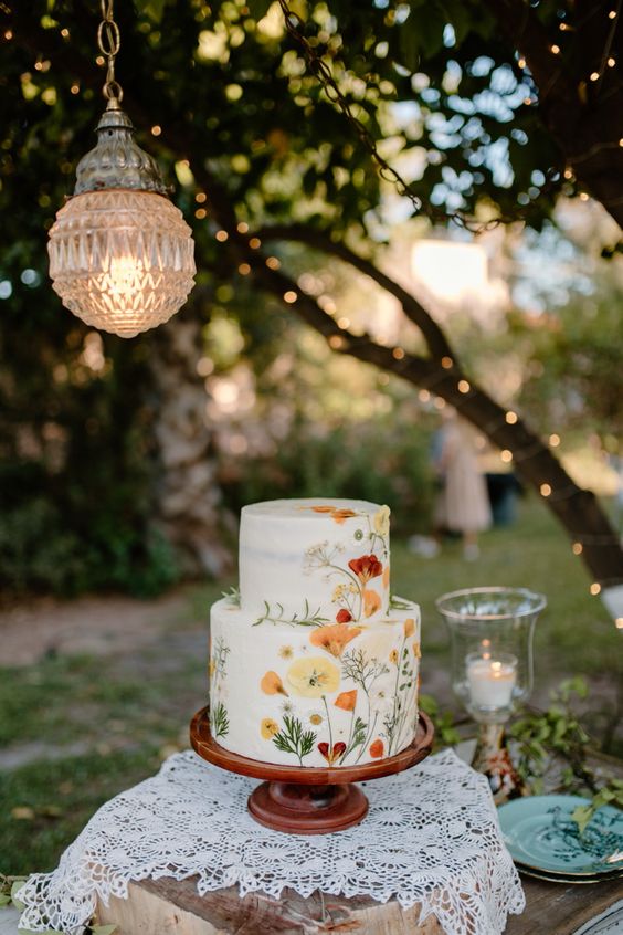 Imagem de um bolo de casamento em uma área verde